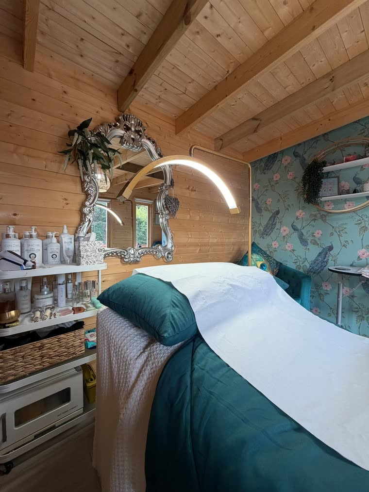 Shelves of Clinicare cleansing and moisturising bottles beside the treatment bed and mirror